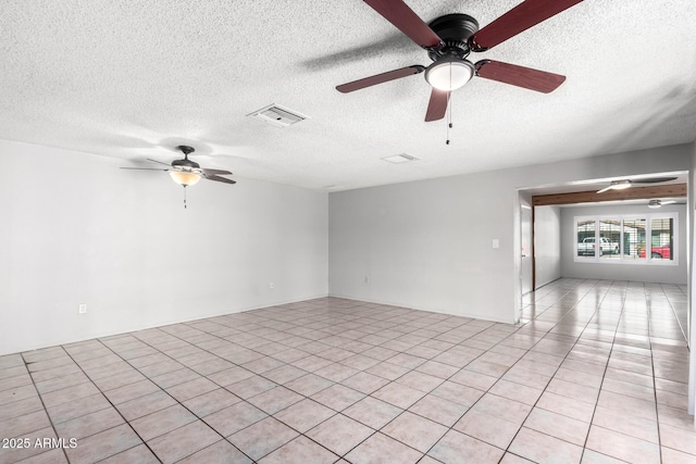 unfurnished room featuring a textured ceiling, ceiling fan, and light tile patterned floors