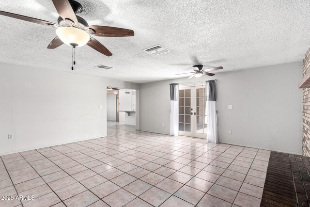 tiled spare room featuring ceiling fan and french doors