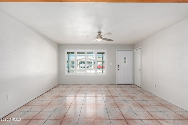 tiled spare room featuring ceiling fan