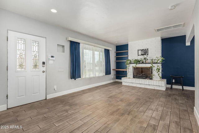 738 S Pomeroy, Mesa, AZ 85210 - unfurnished living room featuring wood finished floors, baseboards, and a brick fireplace
