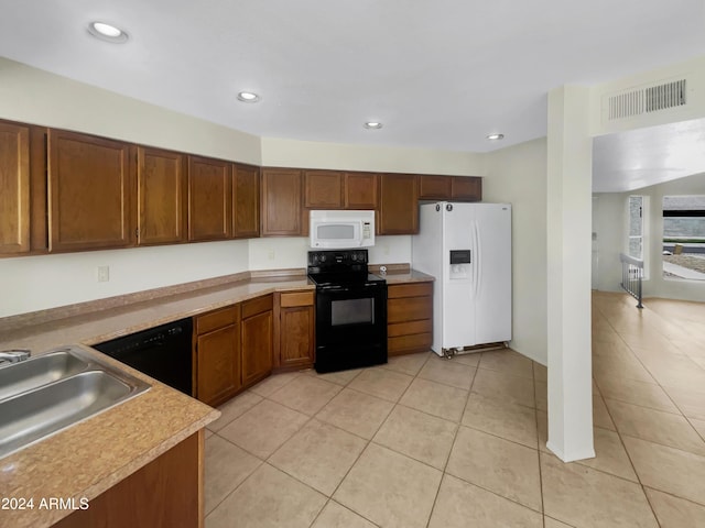 kitchen featuring light tile patterned floors, sink, and black appliances