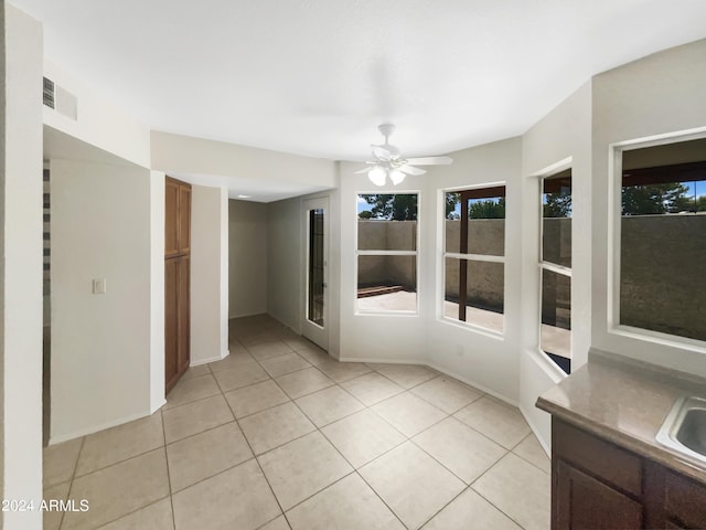 tiled empty room with ceiling fan and sink