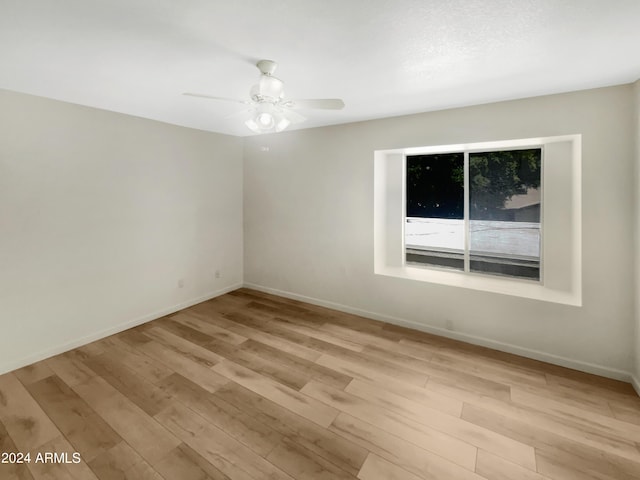 empty room with light wood-type flooring and ceiling fan