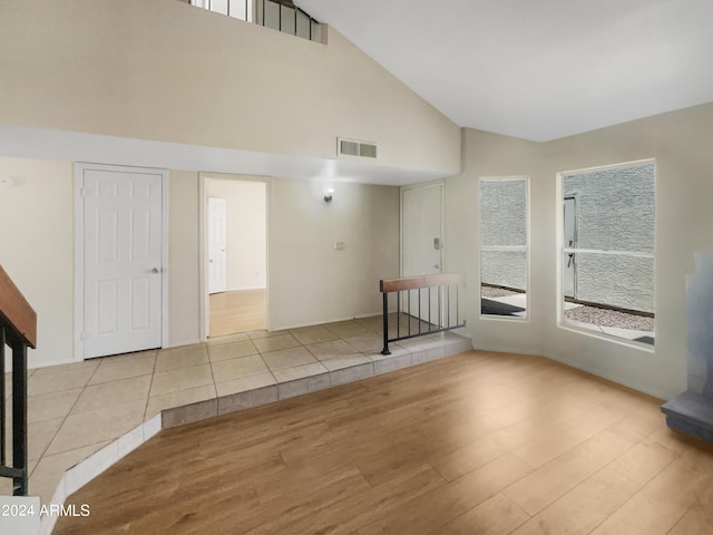 interior space with high vaulted ceiling and light hardwood / wood-style flooring