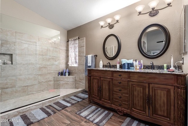 1147 N Marvin St, Gilbert, AZ 85233 - bathroom featuring vaulted ceiling, double vanity, wood finished floors, walk in shower, and a textured wall