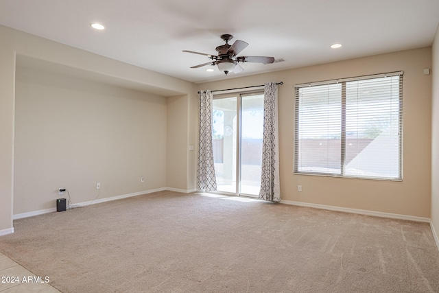 empty room featuring ceiling fan and light carpet