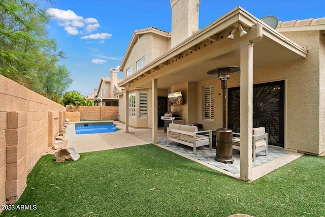 rear view of property with a lawn, a patio, and a fenced in pool