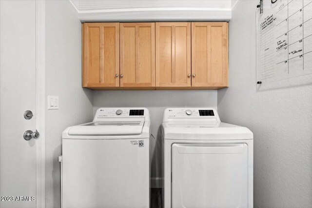 laundry area with cabinets and washing machine and clothes dryer