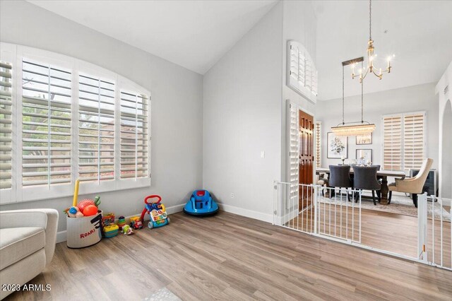 9056 E Maple Dr, Scottsdale, AZ 85255 - rec room with wood finished floors, baseboards, an inviting chandelier, and high vaulted ceiling