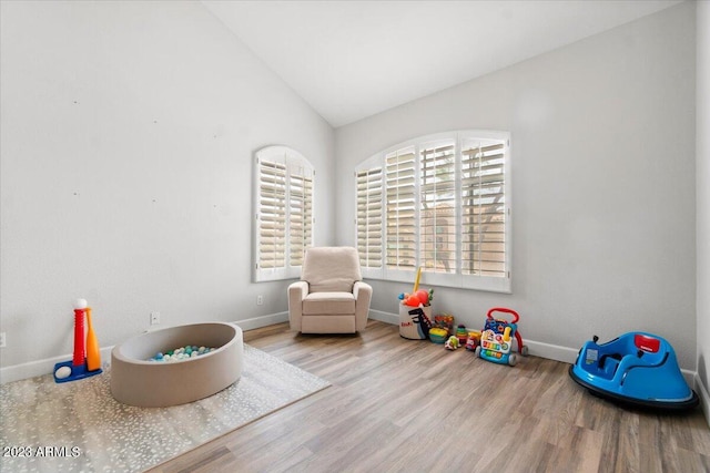 rec room featuring light wood-type flooring, vaulted ceiling, and a wealth of natural light