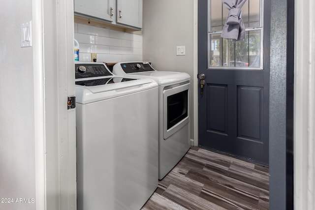 laundry area with cabinets, dark wood-type flooring, and washing machine and clothes dryer