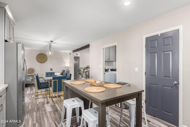 dining area featuring washer and clothes dryer and light hardwood / wood-style floors