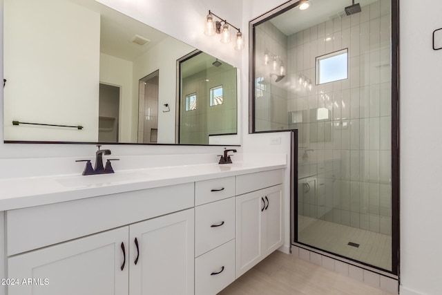 bathroom with tile patterned flooring, vanity, and a shower with door