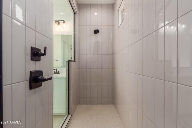 bathroom featuring a tile shower and sink