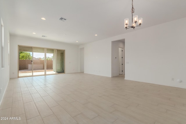 unfurnished room featuring a chandelier