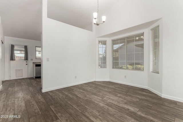 unfurnished dining area featuring dark hardwood / wood-style floors, a notable chandelier, and vaulted ceiling