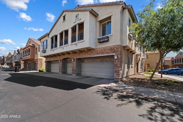 1350 S Greenfield Rd Unit 2133, Mesa, AZ 85206 - view of property featuring stone siding, a residential view, an attached garage, and stucco siding