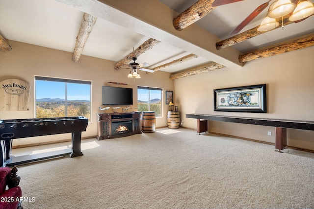 2259 Whitetail Ln, Prescott, AZ 86301 - carpeted living area with beam ceiling, a ceiling fan, a warm lit fireplace, and a healthy amount of sunlight