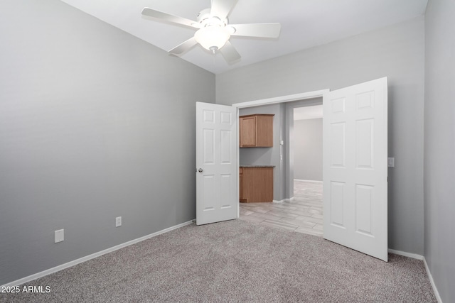 unfurnished bedroom with ceiling fan and light colored carpet