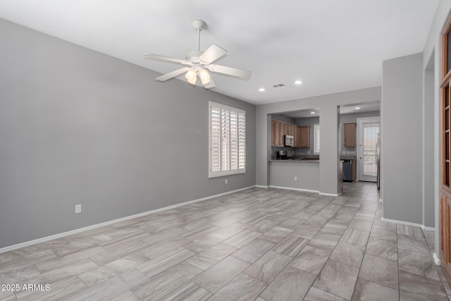 unfurnished living room featuring ceiling fan and a healthy amount of sunlight