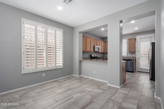 kitchen with stainless steel appliances and light stone countertops