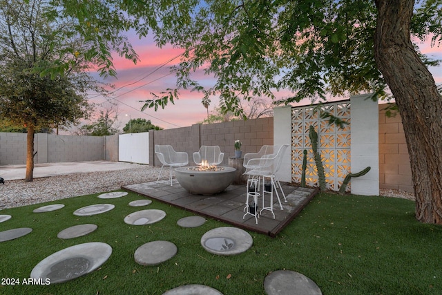 yard at dusk featuring an outdoor fire pit and a patio