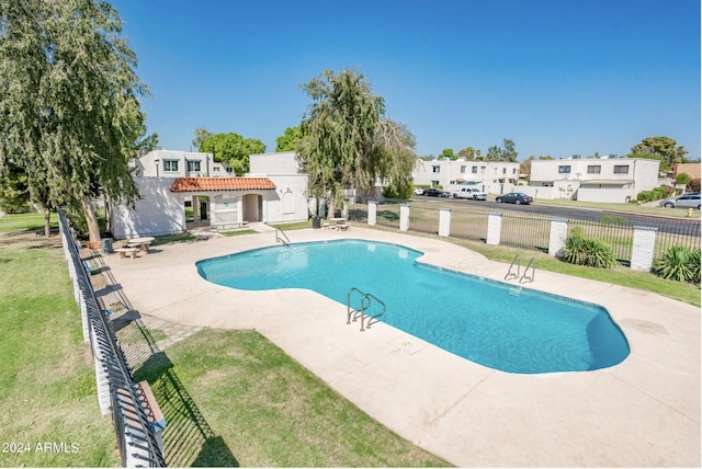 view of pool with a patio area and a lawn