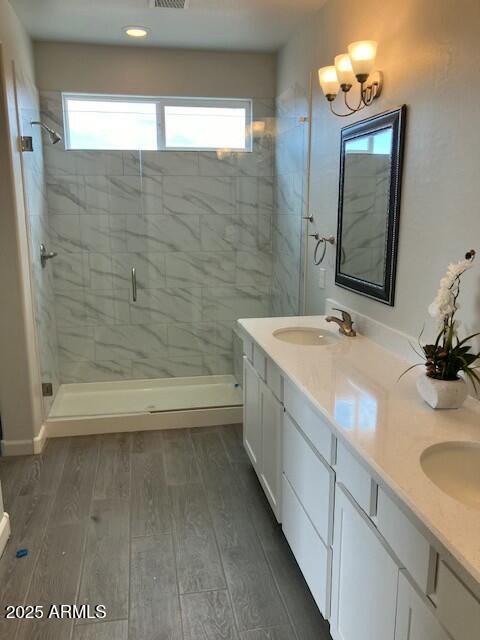 bathroom with vanity, hardwood / wood-style flooring, and walk in shower