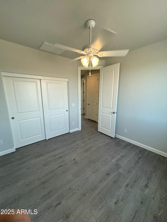 unfurnished bedroom with dark hardwood / wood-style flooring, ceiling fan, and a closet