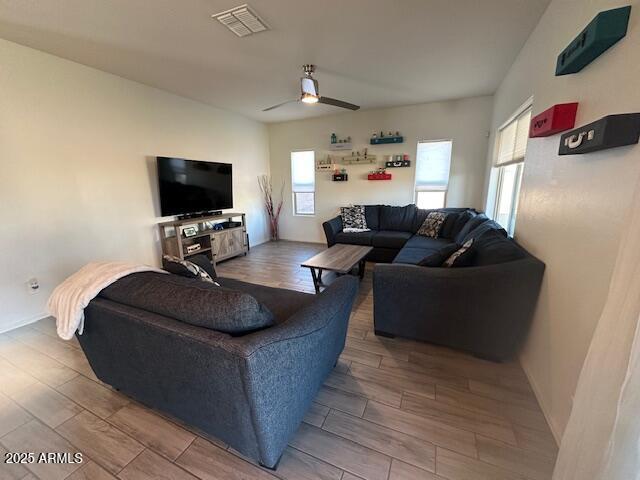 living area with wood tiled floor, visible vents, and ceiling fan