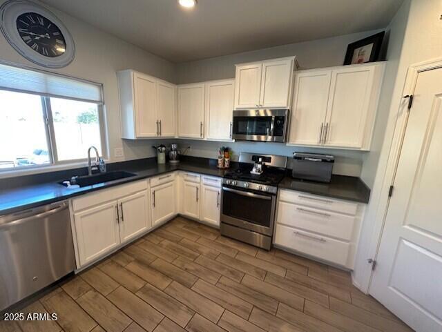 kitchen featuring stainless steel appliances, sink, and white cabinets