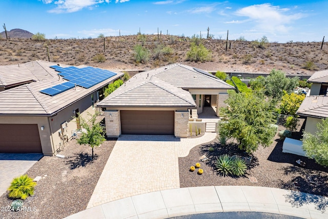 view of front of house with stone siding, a tiled roof, an attached garage, decorative driveway, and stucco siding