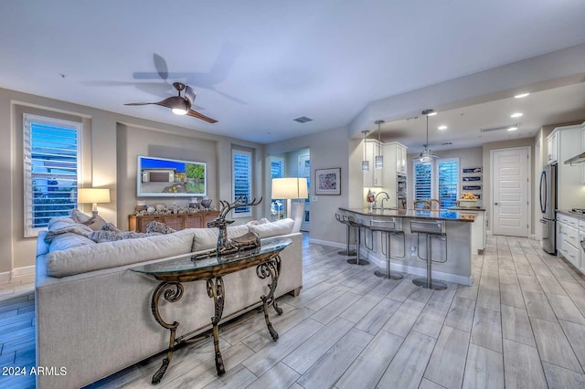 living room featuring recessed lighting, a ceiling fan, baseboards, visible vents, and wood tiled floor