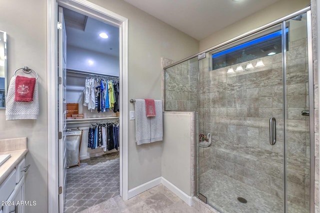 bathroom featuring a stall shower, baseboards, and a walk in closet