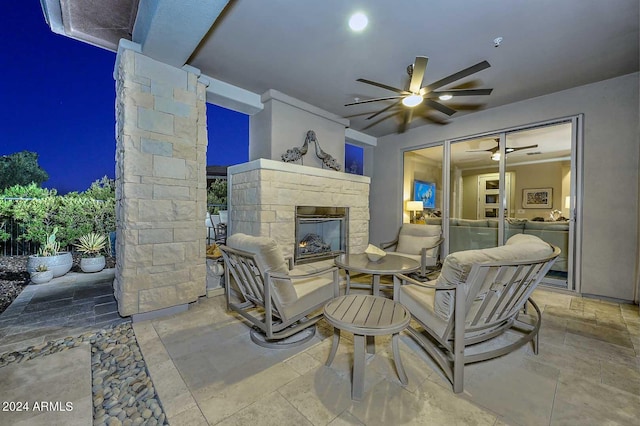 view of patio with ceiling fan and an outdoor stone fireplace