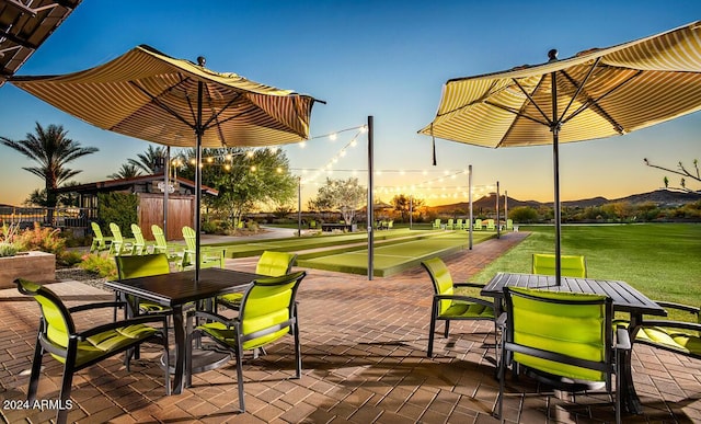 view of home's community with outdoor dining area and a lawn
