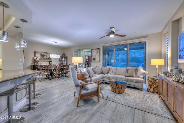 living area with ceiling fan and light wood-type flooring