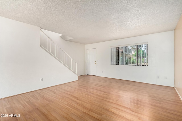 18239 N 40th St Unit 122, Phoenix, AZ 85032 - empty room featuring stairs, light wood-style floors, and a textured ceiling
