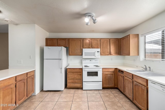 18239 N 40th St Unit 122, Phoenix, AZ 85032 - kitchen featuring white appliances, brown cabinetry, light countertops, light tile patterned floors, and a textured ceiling