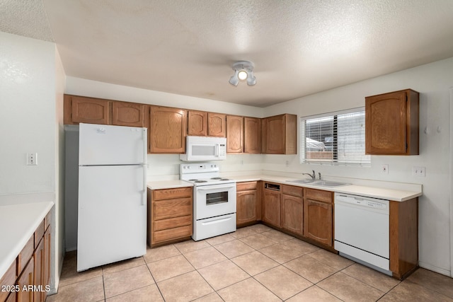18239 N 40th St Unit 122, Phoenix, AZ 85032 - kitchen with white appliances, a textured ceiling, brown cabinetry, light countertops, and light tile patterned flooring