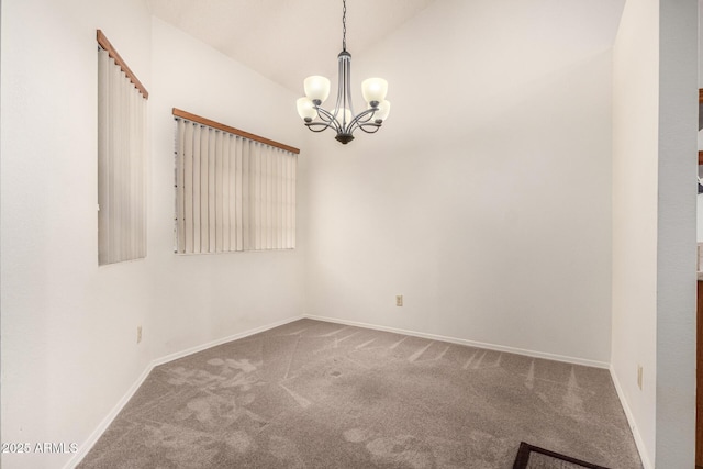 spare room with an inviting chandelier, vaulted ceiling, and carpet