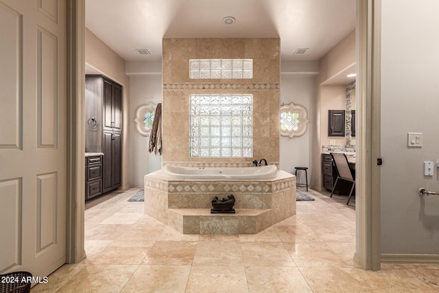 bathroom with vanity, tile patterned flooring, and tiled tub