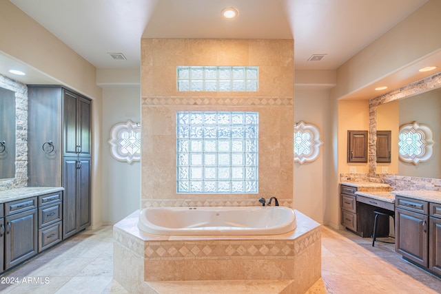 bathroom with a relaxing tiled tub and vanity