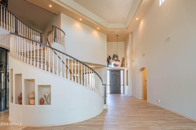 staircase with hardwood / wood-style floors and a high ceiling