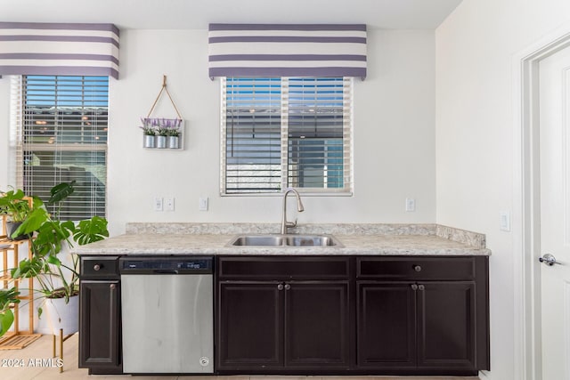 kitchen with light tile patterned floors, stainless steel dishwasher, and sink