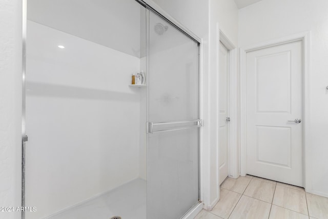 bathroom featuring tile patterned floors and a shower with shower door