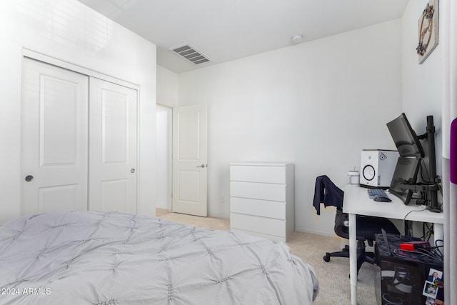 bedroom featuring light carpet and a closet