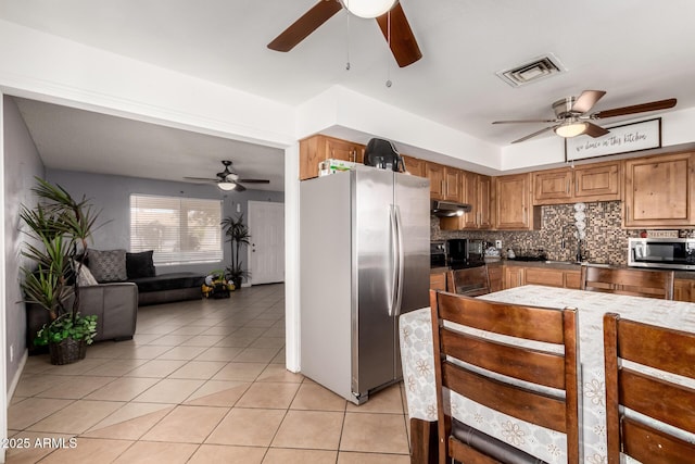 617 E Calle Adobe Ln, Goodyear, AZ 85338 - kitchen with stainless steel appliances, ceiling fan, light tile patterned floors, and tasteful backsplash