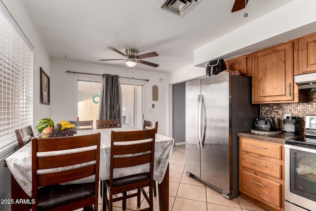 617 E Calle Adobe Ln, Goodyear, AZ 85338 - kitchen with stainless steel appliances, a ceiling fan, decorative backsplash, and range hood