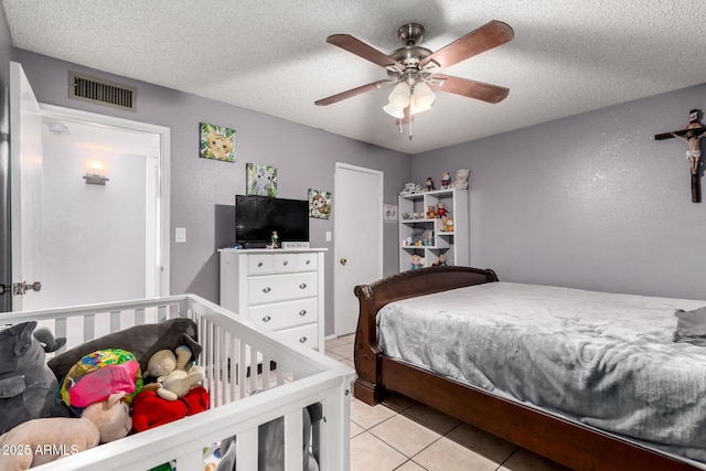 617 E Calle Adobe Ln, Goodyear, AZ 85338 - bedroom with light tile patterned floors, a ceiling fan, and a textured ceiling